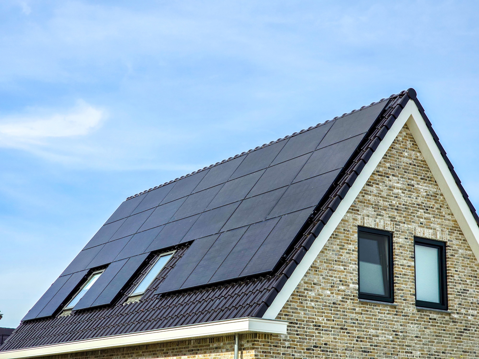 Newly build houses with solar panels attached on the roof against a sunny sky